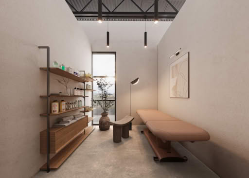 Contemporary beauty salon treatment room with massage bed, wooden shelves, skincare products, and soft ambient lighting.